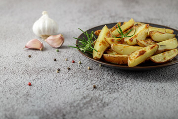 Fresh baked red potatoes with rosemary and garlic on a dark brown plate
