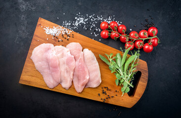 Rohe traditionelle Hähnchen Schnitzel mit Tomaten und Kräuter angeboten als Draufsicht auf einem...
