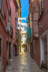 Morning walk in empty Croatian city of Rovinj.Picturesque narrow cobblestone streets,colorful facades,small shops,beautiful European cityscape.Summer holiday background.Real estate concept