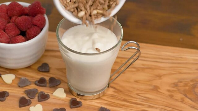 a white yogurt with honet, cereal grain and fresh raspberries