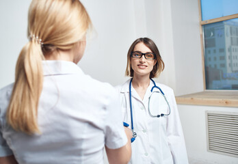 Doctor and patient near window in hospital interior