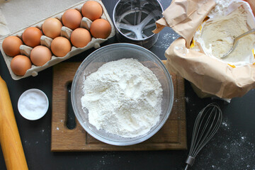 A bowl of flour and egg on the kitchen table.Preparation of home-made dough. Baking ingredients