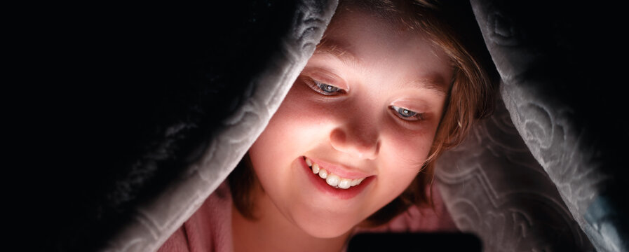 Girl Under The Covers On Internet From Smartphone.