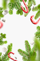 Creative new year concept. Flying traditional Christmas candy cane, green spruce branches, white marshmallows on light background flat lay. Festive decor, sweetness, caramel. Christmas holiday symbol
