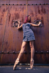 Sweet ballerina girl behind industrial door