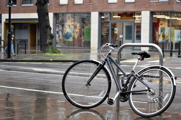 Fototapeta na wymiar Bicycle is locked on the street in a rainy day