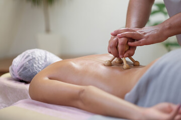 Young woman receiving massage with wooden stamps