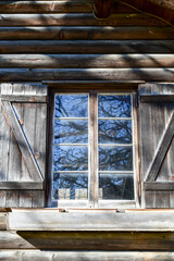 window reflections in weathered wooden barn