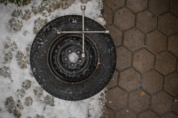 Time to change those tires! Car or suv wheel ready to be mounted on a car with a tyre wrench sitting on top, ready to be used.