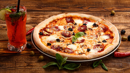 Pizza with meat and olives on a wooden background