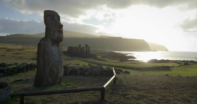 Pan left, Easter Island statue on coastline at sunset