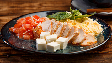 appetizer of tomato and cheese meat sausage on wooden background
