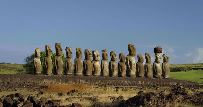 Wide, sun shines on row of Easter Island heads