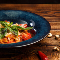 pasta with cherry tomatoes and basil on wooden background