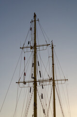 Masts of an old ship against a blue sky.