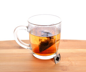 brewed a bag of black tea in a transparent mug on a wooden table.