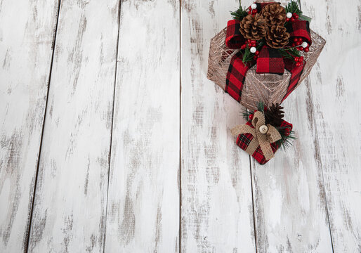 Duo de cadeaux décorés déposés sur une surface en bois peinte en blanc 