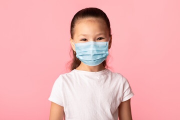 Girl in medical mask isolated over pink studio wall