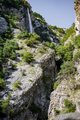 Obraz premium Valley with the Waterfall surrounded by mountains in Swiss Alps, Switzerland