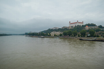 Fototapeta na wymiar Moody panorama of Bratislava city viewed from the Novy bridge looking towards castle over the river on a dull grey day.