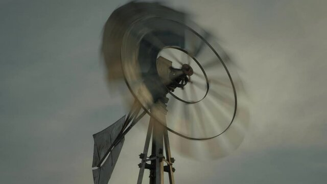 Low angle, windmill spins in rural Utah