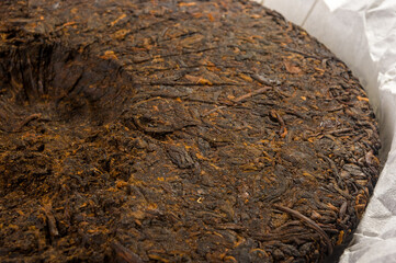 Chinese pressed PU-erh tea on wrapping paper, close-up, macro