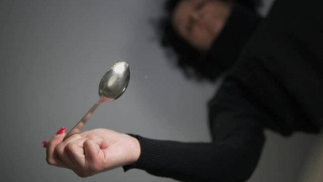 A woman pours salt, spice ingredient into a bowl, slow motion