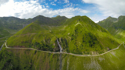 Aerial panorama of a huge waterfall between the high alpine peaks of Fagaras Mountains....