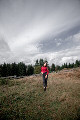 portrait of a young pretty girl who stands alone against a 
background of mountains. beautiful sky, beautiful nature