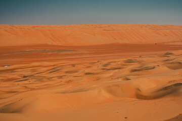 Fototapeta na wymiar Red or orange sand dunes and hills at Al Wahiba desert in Oman