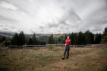 portrait of a young pretty girl who stands alone against a 
background of mountains. beautiful sky, beautiful nature