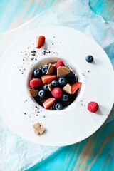 Gourmet dessert with tonka cream, fresh berries and cream, edible soil and finncrisp