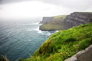 CLIFFS OF MOHER, COUNTY CLARE, IRELAND - SEPTEMBER 13, 2018: Famous Irish landscape on a windy,...