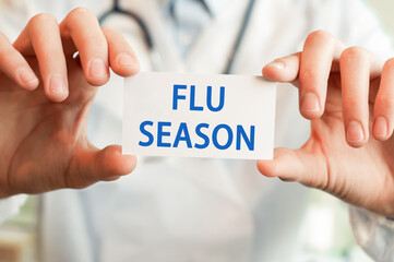 Doctor holding a card with text flu season, medical concept
