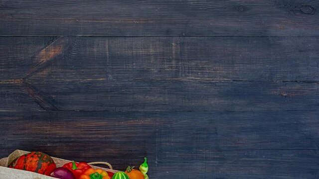 Vegetables in a brown paper bag on a black wood background, stop motion animation
