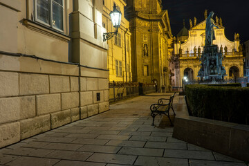 street lights and a bench and in the background a monument to Charles 4 from 1844 in the center of...