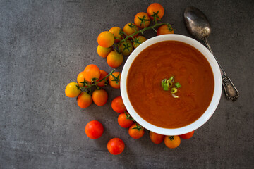 Gazpacho soup top view photo. Dark grey textured background with copy space. Healthy eating concept. 
