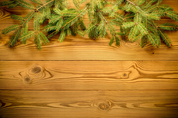 Christmas background with branches of a christmas tree on a wooden board. New year Greeting...