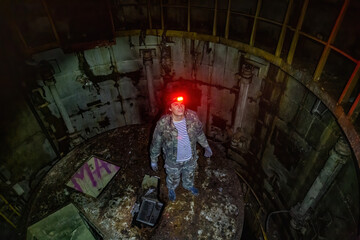 Fototapeta na wymiar Urban explorer in abandoned missile underground command post