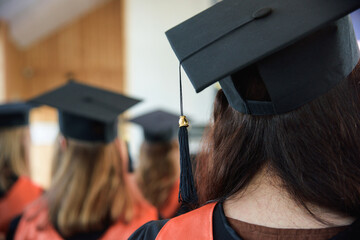 Women graduates of the university in square academic caps with tassel during graduation ceremony