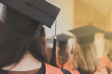 Women graduates of the university in square academic caps with tassel during graduation ceremony