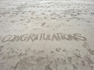 Congratulations written in the sand