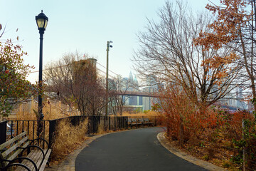 Alley of Main Street Park on the background of famous Brooklyn bridge in New York in winter day.