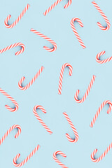 Christmas composition. Pattern made of red and white candies on blue background. Christmas, winter, new year concept. Minimal style. Flat lay, top view.