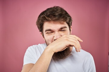 bearded man in white t-shirt emotions displeased facial expression studio pink background