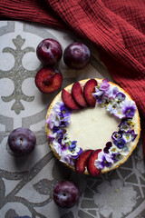 Cheesecake with plums. Homemade dessert close up photo. Gray background with copy space. 

