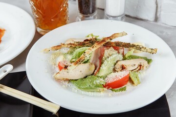 Fresh caesar salad with chicken breast and tomatoes