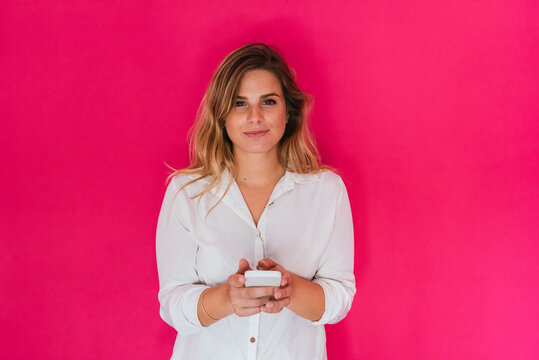 Girl with mobile phone on pink