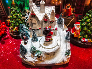 A red christmas snow globe on a table. Small Christmas decoration objects.