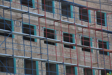 Close up on a building under construction and scaffolding.